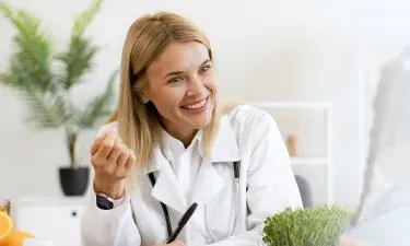 New Mexico family nurse practitioner smiling with pediatric patient during appointment